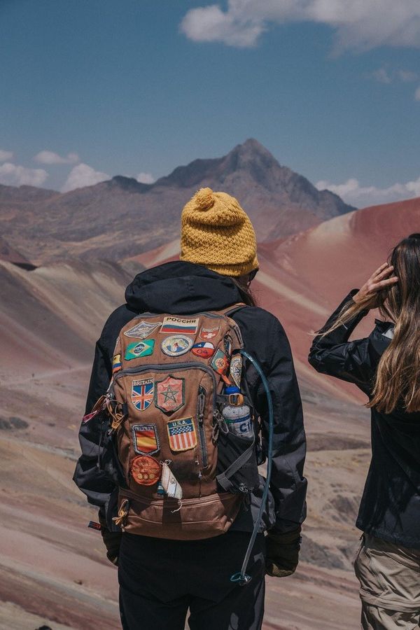 Viajante de costas, com uma mochila cheia de patches de vários países