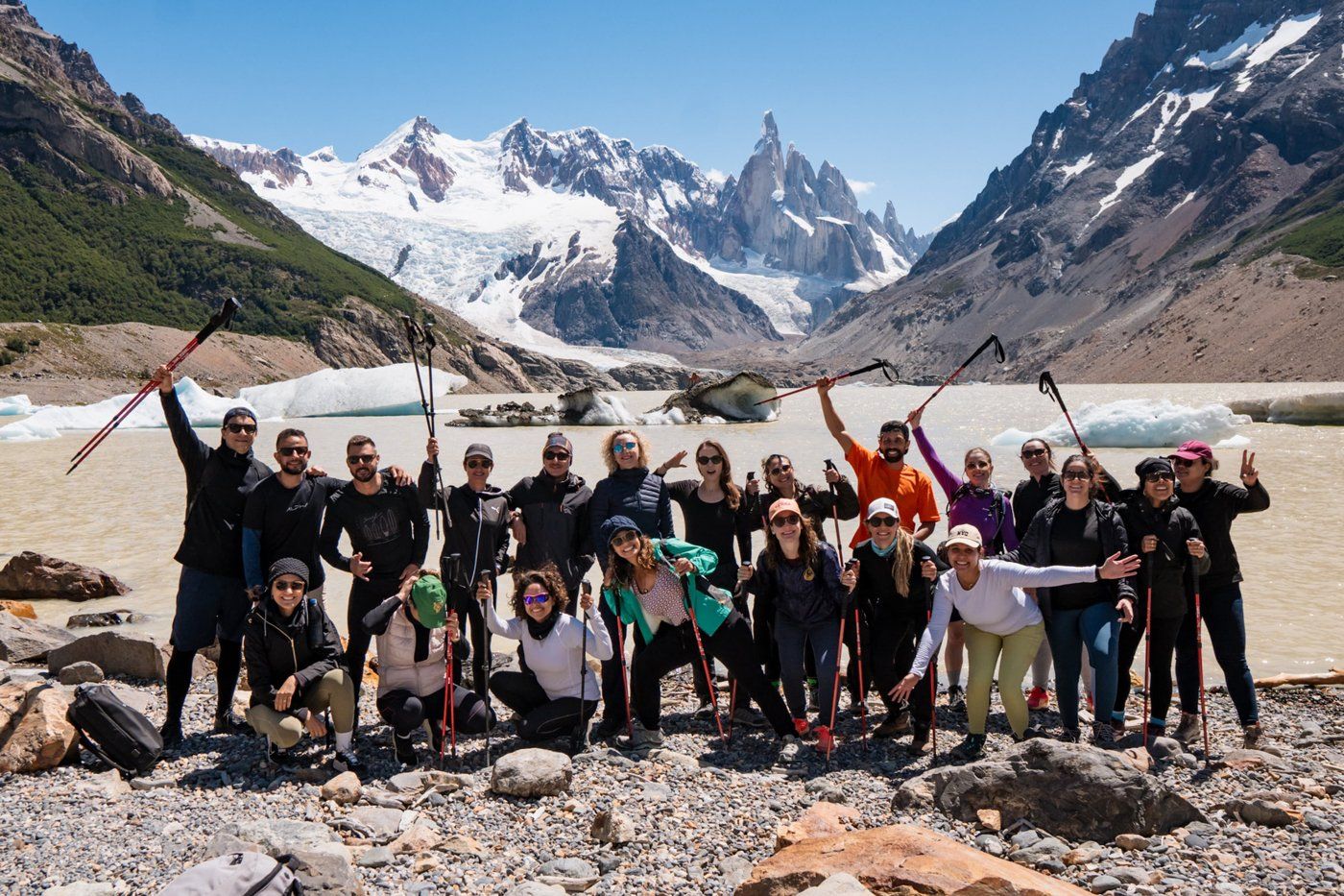 Grupo de viajantes comemorando na Laguna Torre, com o Cerro Torre ao fundo, na Patagônia argentina